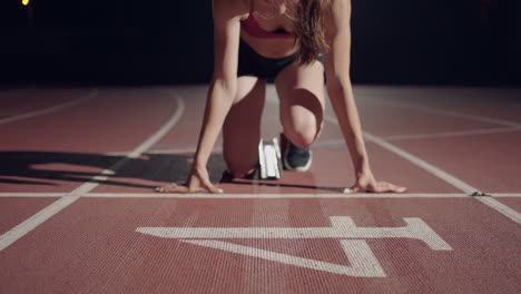 slow-motion-female-runner-at-the-start-close-up-in-the-dark-at-the-stadium-professional-runner-athletic